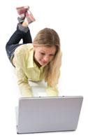 Blond woman laying down working on a laptop