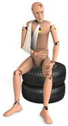 Crash test dummy in a sling sitting on a pile of tires