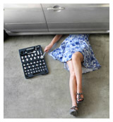 Woman in a dress repairing a car