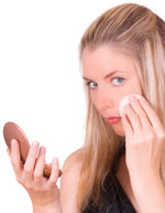 Woman using a makeup compact