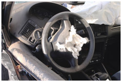 A wrecked car with deployed airbag