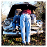 A man and his kids inspecting a car